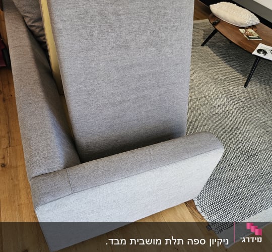 ספה אפורה עם כריות על רצפת עץ